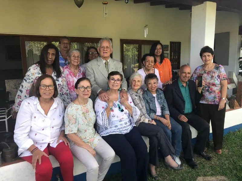 Un grupo de varias generaciones comparte en el porche de una casa