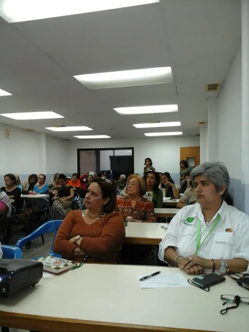 Asistentes de un curso siguen la sesión desde sus mesas de trabajo